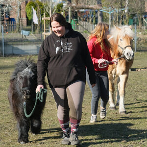 Nahaufnahme zwei Mädchen führen Ponys an Trensen