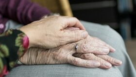 Nahaufnahme von Händen älterer Personen, die aufeinander liegen