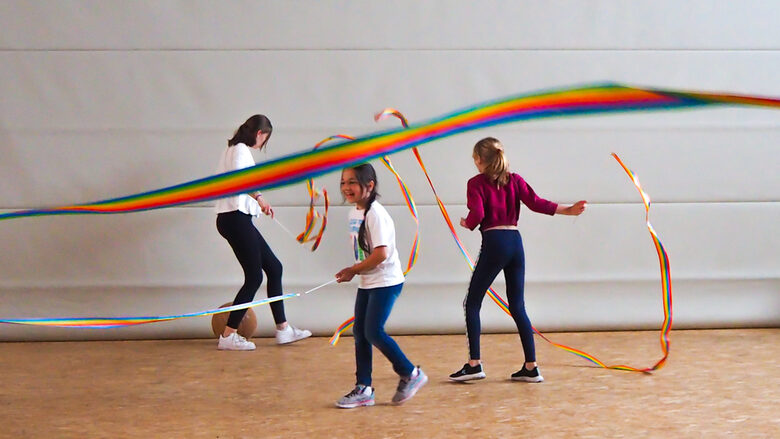Mädchen spielen mit Regenbogenband