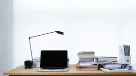 Symbolbild Schreibtisch mit Laptop und diversen Ordnern